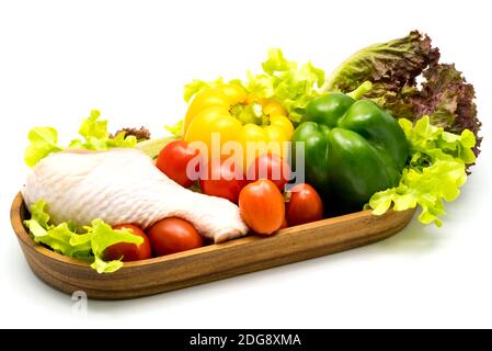Raw chicken and vegetables in wooden tray Stock Photo