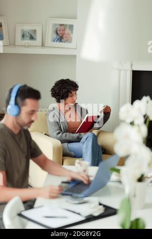 Couple reading and paying bills online at home Stock Photo