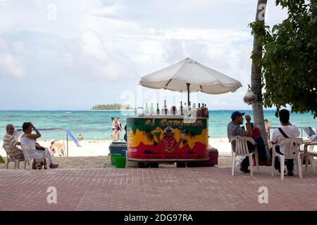 San Andres Island, Colombia, South America - People at a beach stand selling drinks in the main beach of the island. Stock Photo