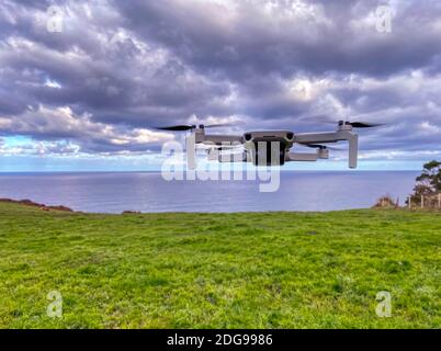 Drone with digital camera flying in the sky. Modern technology for aerial video and photography. Stock Photo