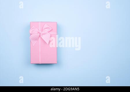 Gift rectangular pink box with bow on a pure blue background. Stock Photo