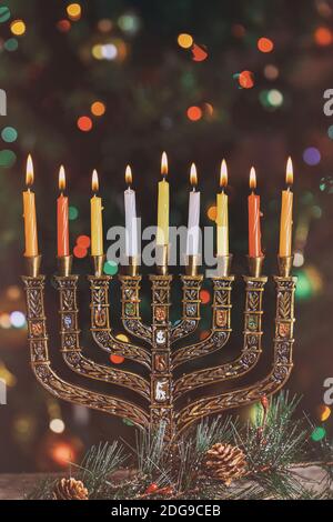 Burning hanukkah candles in a menorah on colorful candles from a menorah Stock Photo