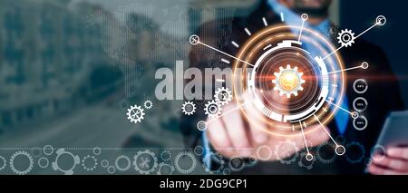 Businessman touching brain in cogwheel. Optimisation of construction. Industry 4.0. Mixed media. Stock Photo