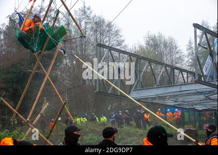 Denham, Buckinghamshire, UK. 8th December, 2020. A huge Police and HS2 operation is underway to try to remove Veteran eco activist Dan Hooper known as Swampy who is currently locked onto a 30 feet tall high  bamboo structure in the River Colne in Denham Country Park. HS2 are building a temporary bridge across the river and Anti HS2 Rebellion activists are are trying to stop the bridge being built and further trees being destroyed by HS2 for the controversial High Speed Rail link. Credit: Maureen McLean/Alamy Live News Stock Photo