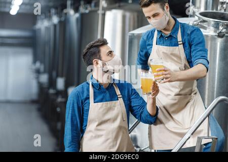 Tasting and checking drink at plant during coronavirus quarantine Stock Photo