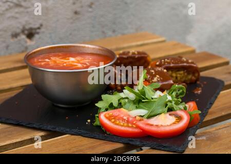 Classic, Italian arancini. deep fried Rice balls with minced meat and some vegetables inside. Tasty crunchy food with peanuts sauce and tomatoes soup Stock Photo