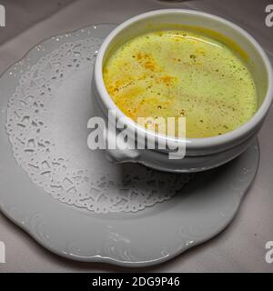 Asian homemade bowl of pumpkin soup with cream and green curry on white plate. Stock Photo