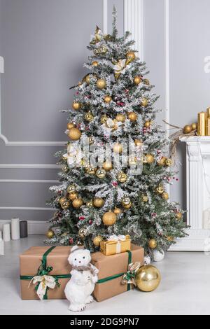 Big beautiful New Year tree with gifts in a white decorated hall for the New Year Stock Photo