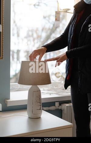 Woman hand replacing light bulb for energy saving one. Energy efficiency at home Stock Photo