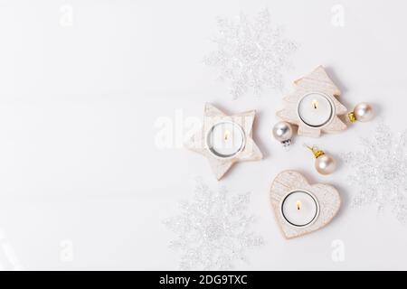 White Christmas holiday composition. Festive creative white pattern, xmas decor holiday ball with candles, snowflakes on white background. Stock Photo