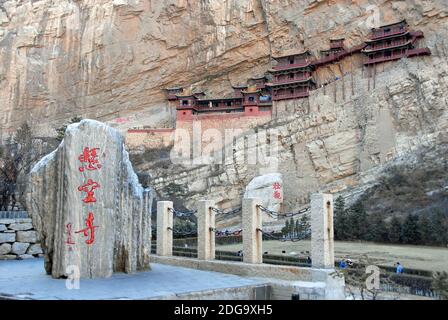 The Hanging Temple or Hanging Monastery near Datong in Shanxi Province, China. The Temple seen with a monument in the foreground. Stock Photo