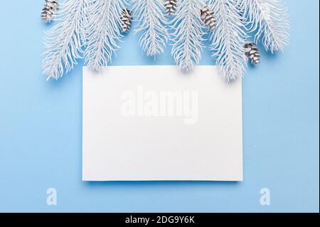 Merry Christmas and Happy New Year greeting card branches frame or banner. Fir tree on blue background top view. Winter holiday theme Stock Photo