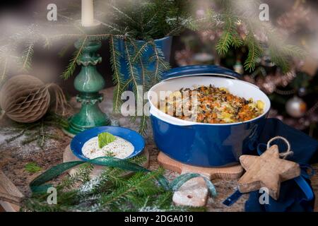 Christmas festive table decoration for romantic dinner with roasted chicken in the blue pot Stock Photo