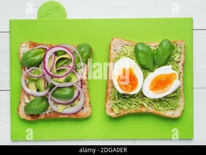 Two avocado toasts on green background Stock Photo