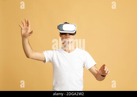 Guy in modern VR glasses exploring virtual reality Stock Photo
