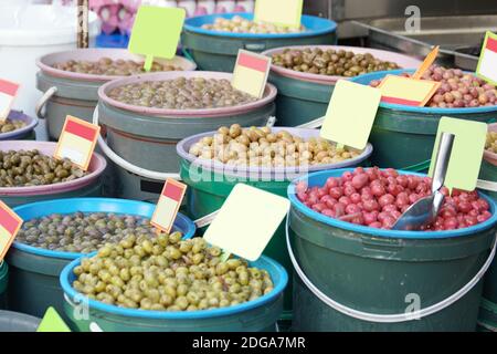 Different types of olives on display at market. Stock Photo