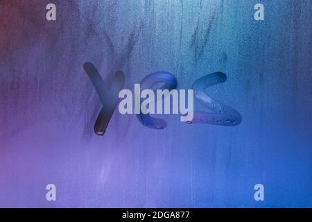 word yes handwritten on foggy night window glass surface Stock Photo
