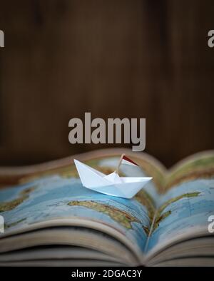 Paper Boat on Worldmap Stock Photo