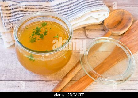 fresh cooked bone broth in a jar on wooden table Stock Photo