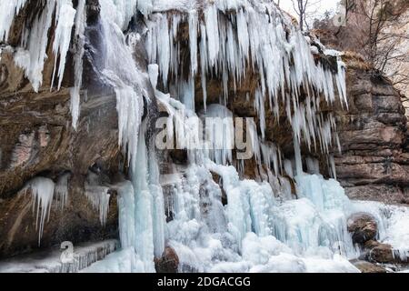 Large frozen icicles on site of waterfalls in mountainous area Stock Photo