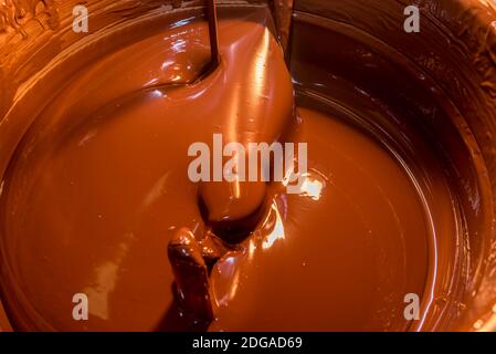 melted dark chocolate in machine for tempering chocolate Stock Photo
