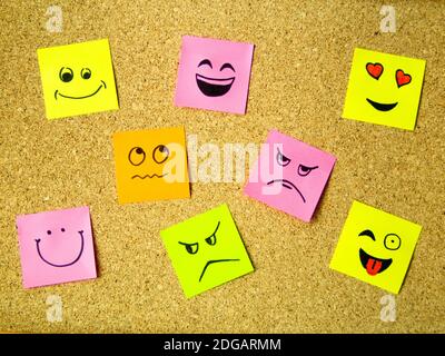 cork board with colorful post its representing various emoticons with various emotions communication concept Stock Photo