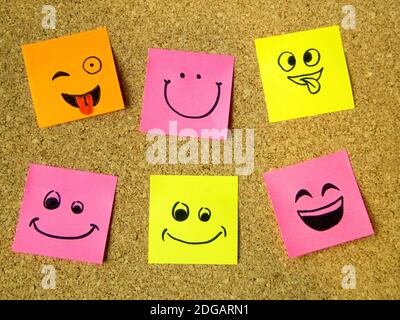 cork board with colorful post its representing various emoticons with various emotions communication concept Stock Photo