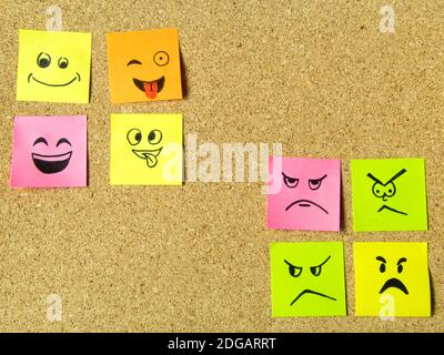 cork board with colorful post its representing various emoticons with various emotions communication concept Stock Photo