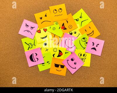 cork board with colorful post its representing various emoticons with various emotions communication concept Stock Photo