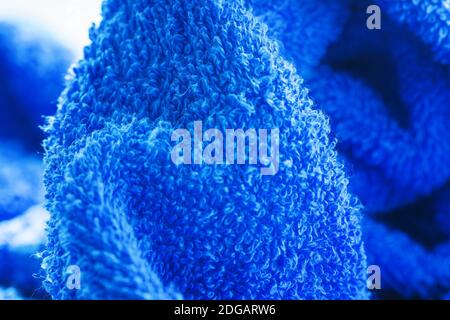 Blue terry towel texture closeup. Soft cotton towel backdrop, fabric background. Selective focus, shallow depth of field Stock Photo