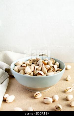 Pistachios. Pistachios in a ceramic plate and a napkin on the table Stock Photo