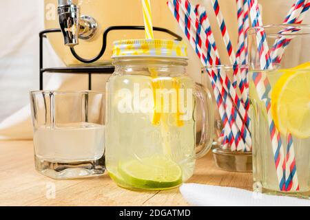 https://l450v.alamy.com/450v/2dgatmd/dispenser-of-natural-drinks-with-homemade-citrus-juice-on-a-wooden-surface-different-types-of-glasses-and-jugs-with-sorbet-and-ice-with-juice-and-a-2dgatmd.jpg