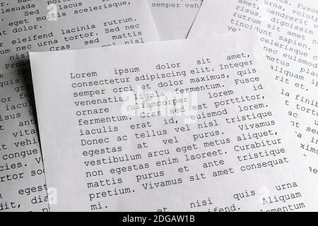 lorem ipsum dolor sit amet concept. selective focus photo of paper sheets with publishing and graphic design placeholder text on them. Stock Photo