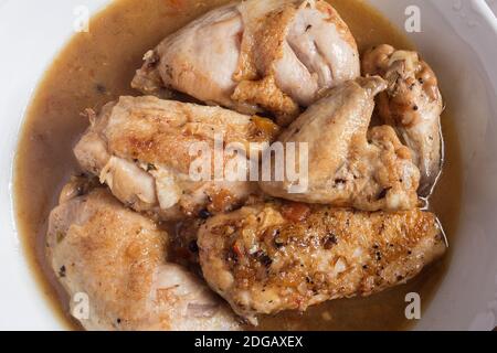 Overhead view of a plating food of chicken food in vegetable sauce with cognac in a ceramic dish. Recipes of meat and vegetables. Stock Photo