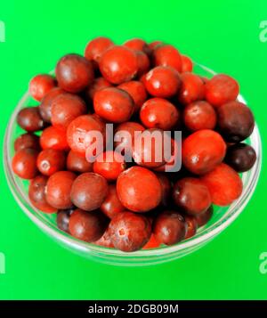 Freshly washed raw cranberries in a glass bowl on green background Stock Photo