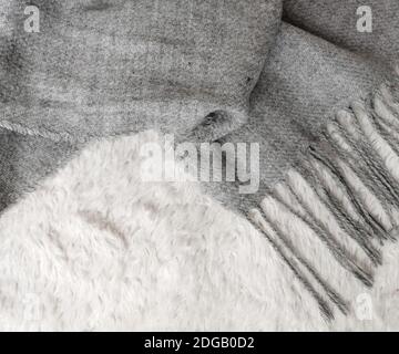 Woolen scarf of grey color on white background, top view, space for text. Winter clothes Stock Photo