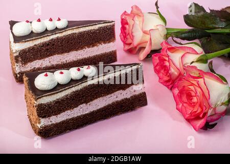 Festive cake with chocolate and cottage cheese layer. Two portions. On a pink background. Birthday, holidays, sweets. Copy space. Stock Photo