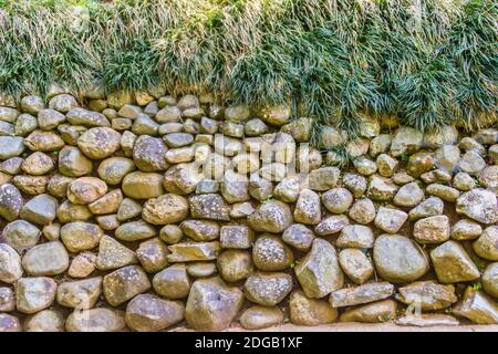 Rock wall seamless texture for background. Decorative uneven cracked real stone wall surface with cement. Grungy stone wall background Stock Photo