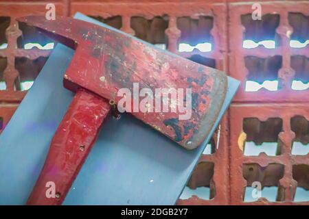 Old red fire fighting ax hanging on the wall. Fire ax is one of the fire fighting equipment on board. Stock Photo