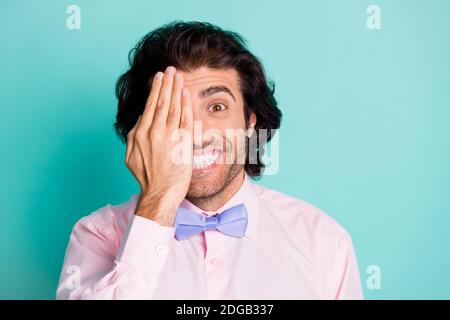 Photo portrait of guy hiding half face behind one palm isolated on pastel teal colored background Stock Photo
