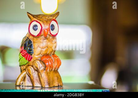 Colorful wooden carved owl doll shown on the showcase for sale in the market Stock Photo