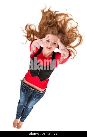 High angle full length of a young woman lying on white with outstretched blond hair and hands stretched to the camera smiling happily at the camera. Stock Photo