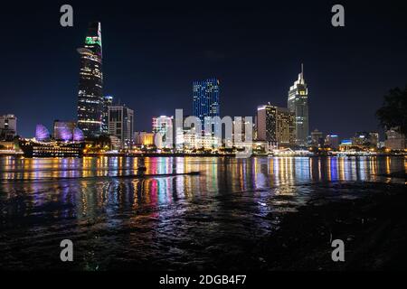Scenic colourful night view of the skyline of Ho Chi Minh City reflected on the Saigon River. Skyscrapers and modern buildings are located in district 1.
