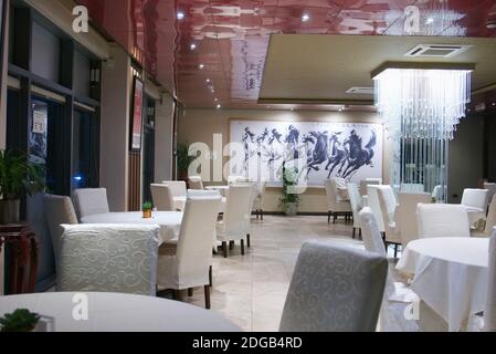 Empty Chinese restaurant with white chairs &  tablecloths. Lack of business during Tier 2 Covid19 restrictions. Jun Ming Xuan, Colindale, London. Stock Photo