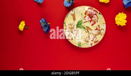 Flat design photo on red background with place for text, decorative flowers, blank notepad, top view, beautiful composition Stock Photo