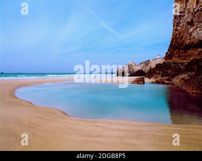 Beach with a lighthouse in the background, Pointe Du Toulinguet, Crozon, Finistere, Brittany, France Stock Photo