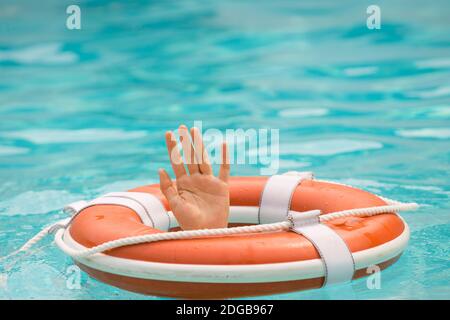 The concept of help, rescue, drowning, storm. Thrown life buoy saving drowning person. Life buoy. Lifebuoy in water. Life ring floating in a sea, life Stock Photo