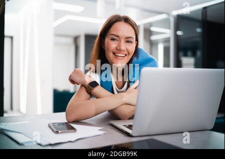 Portrait of happy successful caucasian woman in informal wear looking and smiling at the camera. Attractive female manager on self isolation after Stock Photo