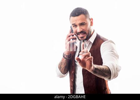 Man talking on the phone. Cheerful young handsome man talking on mobile phone. Portrait of handsome excited cheerful joyful guy wearing casual. Using Stock Photo