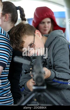 Scottish International Airshow, 3 Sept 2016, Low Green Ayr, Ayrshire, Scotland, UK. Young boy looks through rifle sight on military display stand Stock Photo